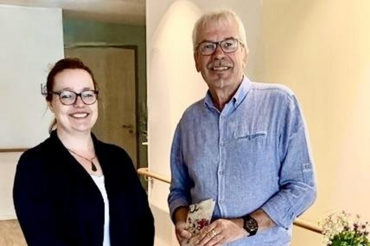 Ein Mann und eine Frau stehen in einem Raum mit einem Tisch.