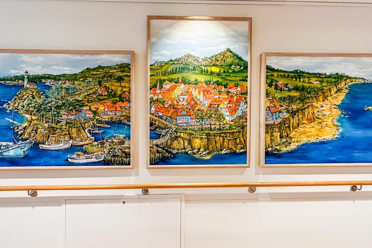 Drei Gemälde an der Wand eines Raumes.