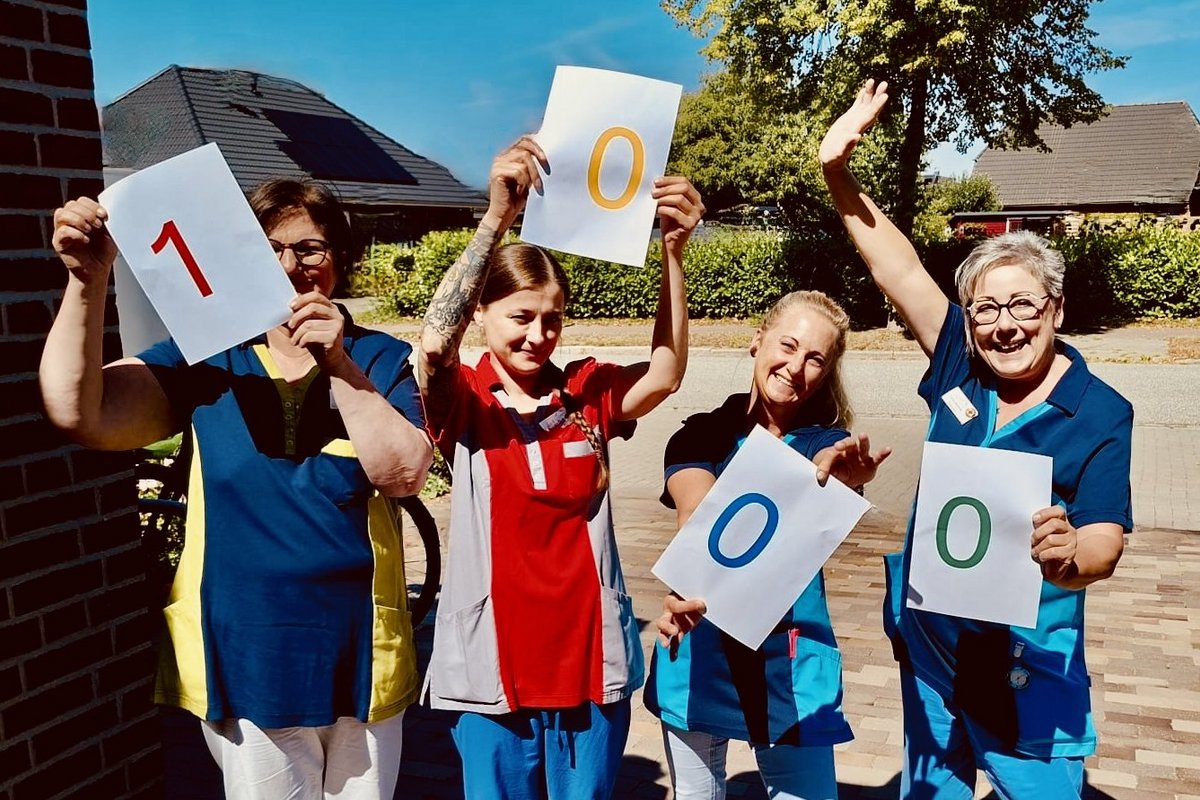 Unser Team mit den Zahlen eintausend in der Hand 