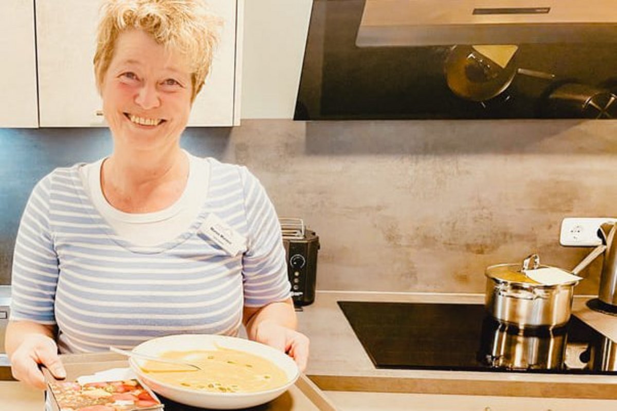 Ehrenamtliche Hospizmitarbeiterin mit einem Teller Kürbissuppe.