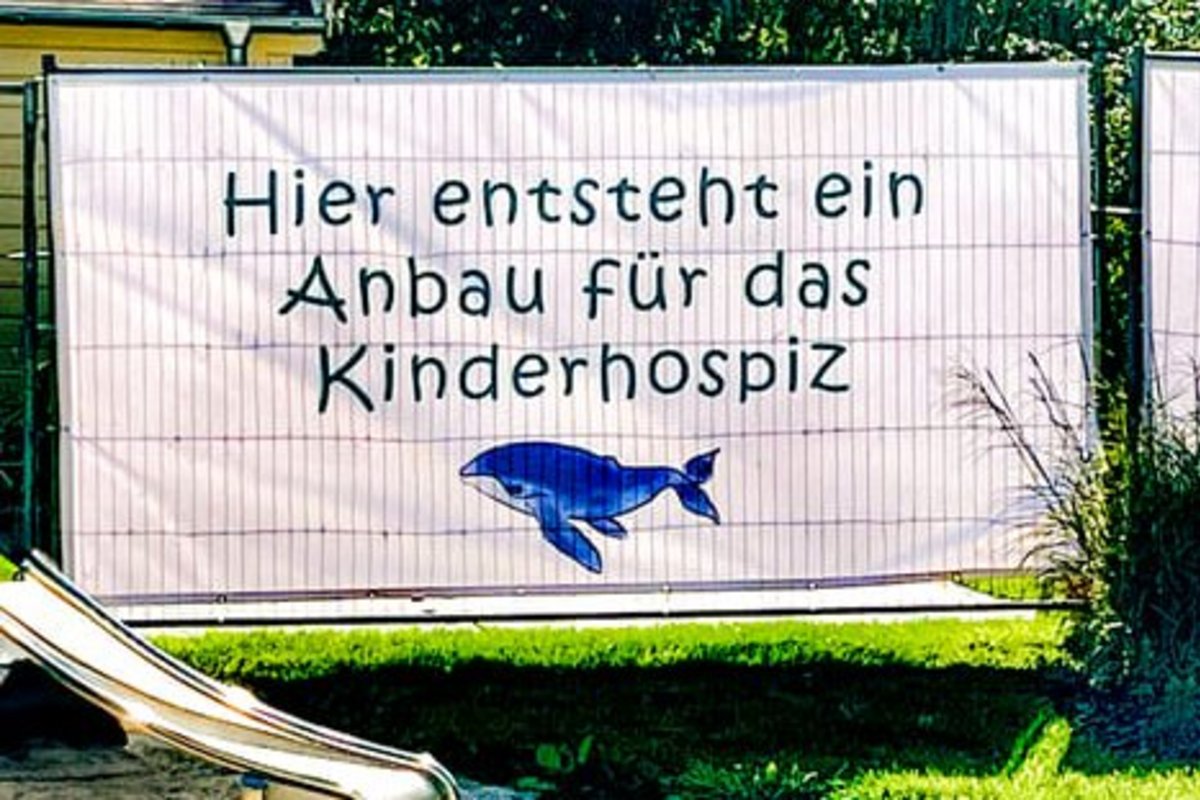 Bauzaun mit Bauplakat mit Logo des Kinderbereiches.