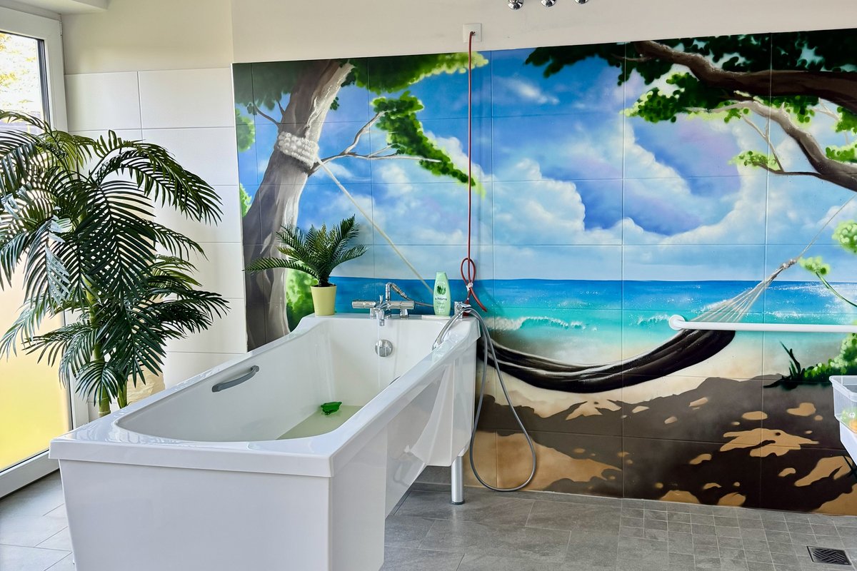 Pflegebad mit Badewanne und Graffiti Strand Bild im Hintergrund 
