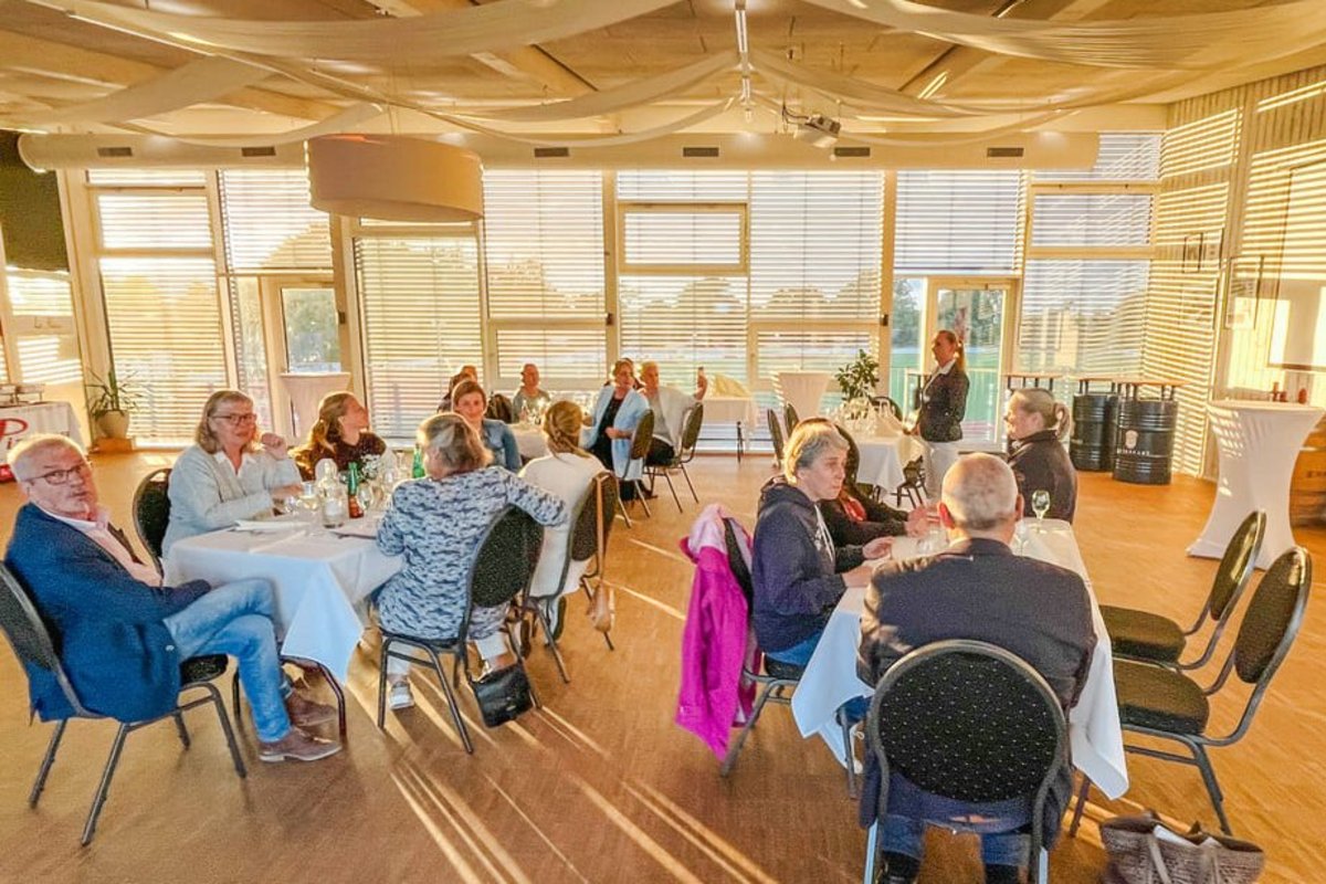 Mitarbeiter beim Sommerfest in sonnendurchflutetem Raum.