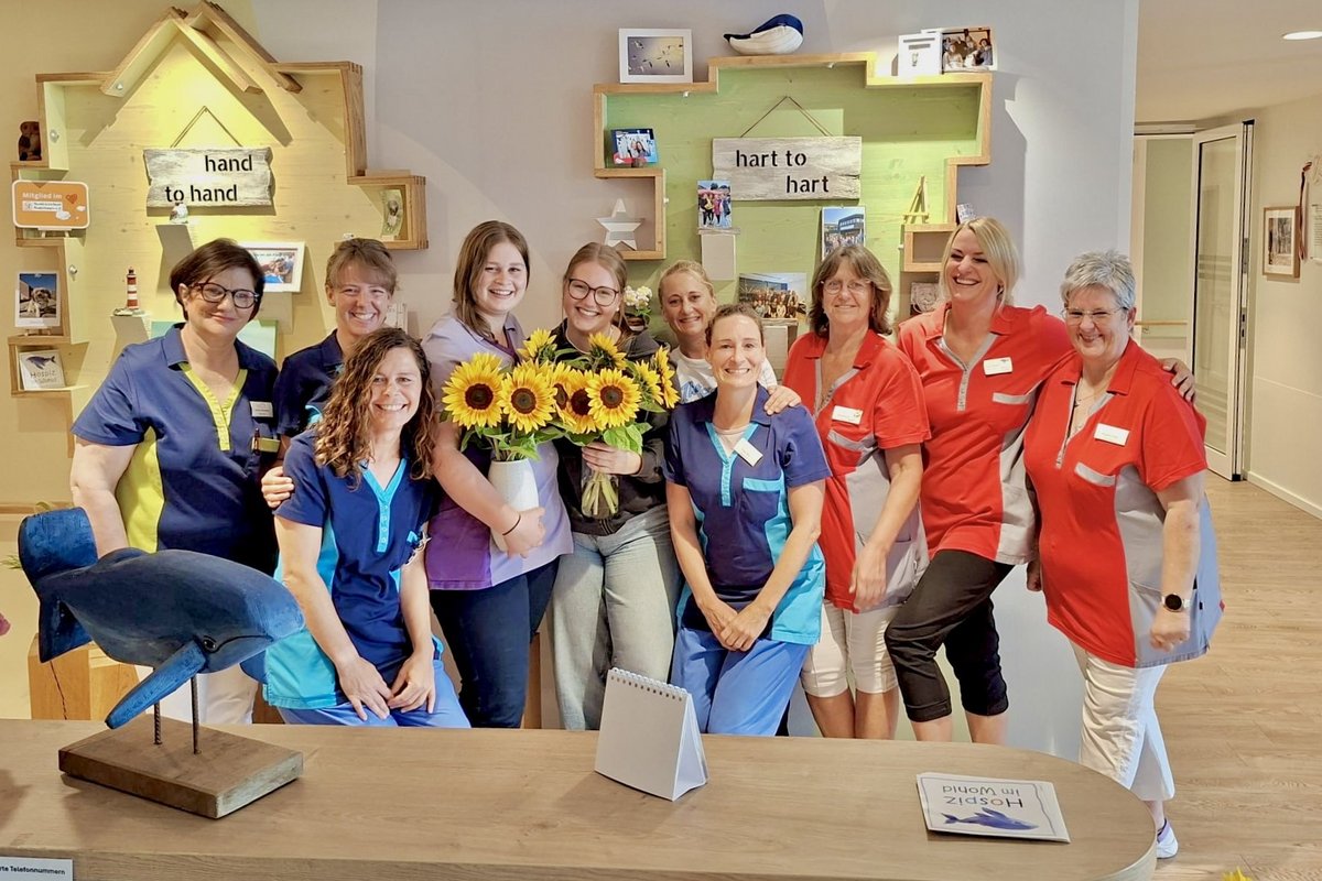 Ein Gruppenbild des Pflegeteams mit einem Blumenstrauss.